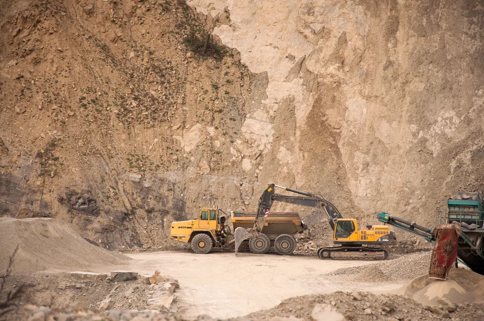 Excavator and haul truck at an industrial quarry